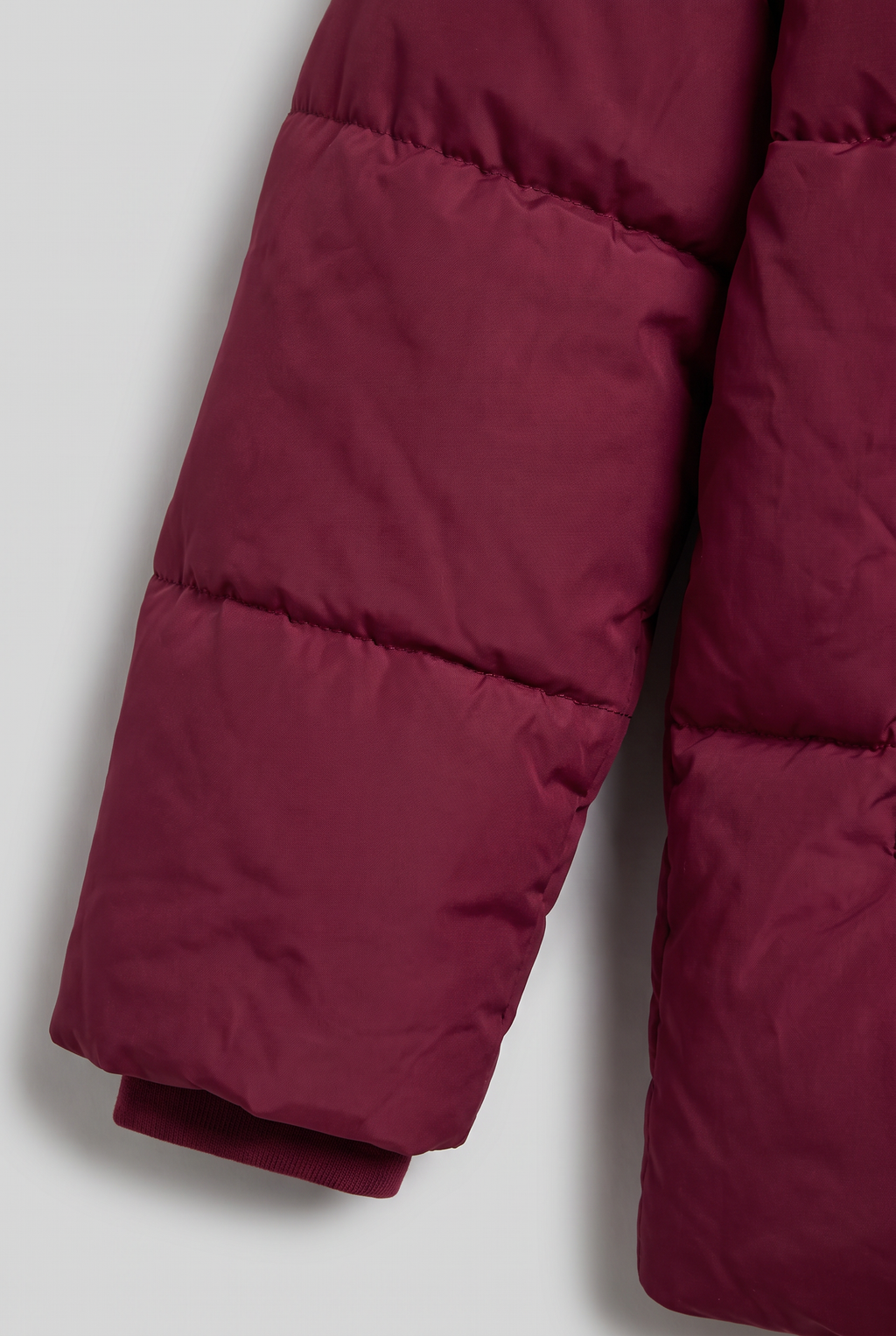 Women's Oversized Padded Puffer Jacket with Detachable Hood and Pockets in Burgundy – Sleeve Detail