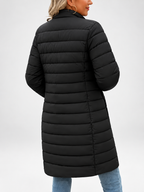 Women's longline puffer coat in black, three-quarter view