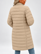Women's longline puffer coat in khaki, front view with a coffee cup