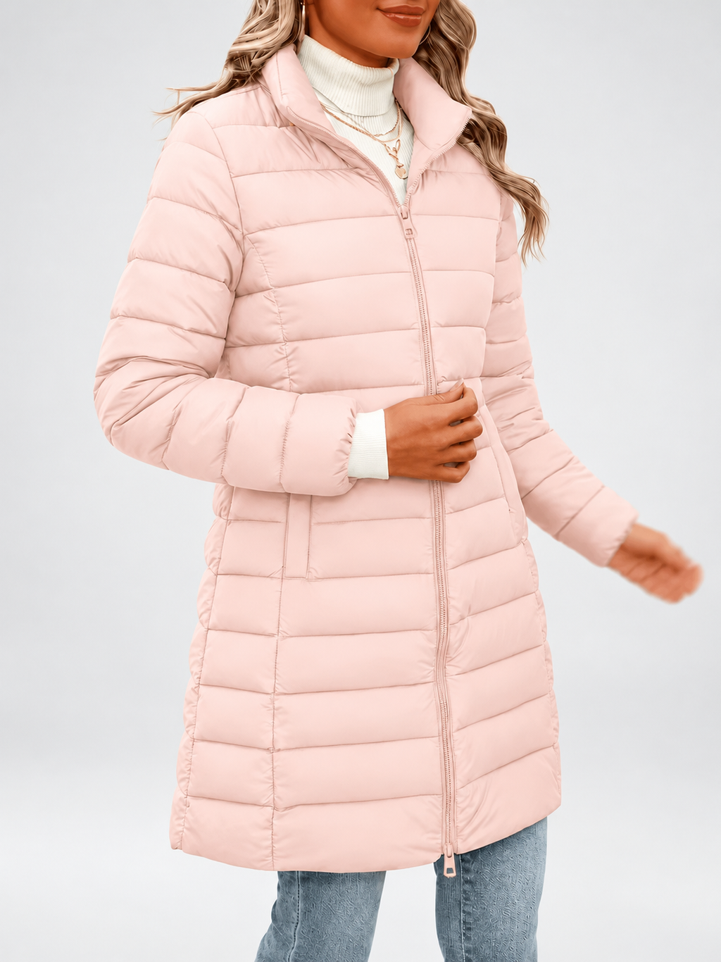 Women's longline puffer coat in light pink, front view with a coffee cup