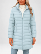 Women's longline puffer coat in sky blue, front view with stand collar and zip fastening