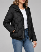 Women's Quilted Jacket with Ribbed Knit Hood and Snap Flap Pockets in Black – Three-Quarter View