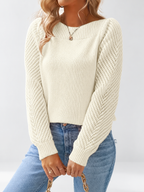 Women's round neck knitted jumper in Apricot, seated view with open knit sleeves